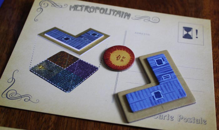 Der Spieler entscheidet sich für die Postkarte Metropolitain und erhält ein zusätzliches Gebäude.